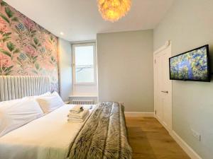 a bedroom with a bed and a chandelier at Beautiful 2BR, Private Entry in Vibrant Leith in Edinburgh