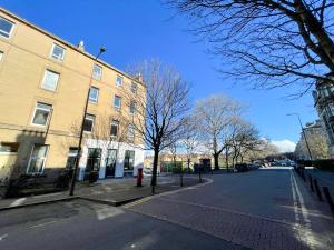Une rue vide à côté d'un grand bâtiment en briques dans l'établissement Beautiful 2BR, Private Entry in Vibrant Leith, à Édimbourg