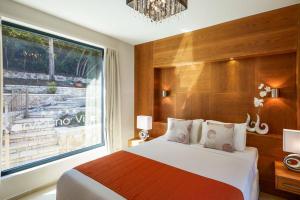 una camera da letto con un letto e una grande finestra di Villa Michael Karvouno Villas a Sivota Altre 15 foto