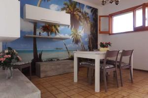 ein Esszimmer mit einem weißen Tisch und Stühlen in der Unterkunft Appartamento Mimosa by Salento Affitti in Baia Verde