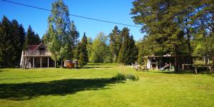 un ampio cortile con una casa sullo sfondo di Metsaräägu Wellness 