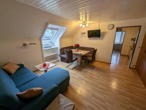 uma sala de estar com um sofá azul e uma mesa em C4 Albmatte-FEWO Sauna, Hallenbad Außenbecken Massagen nebenan em Menzenschwand