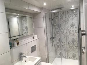 a bathroom with a shower and a sink and a mirror at Rum Doodle, Windermere B&B in Windermere