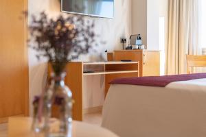 a hotel room with a table with a vase of flowers at La Sort Boutique Hotel in Moraira