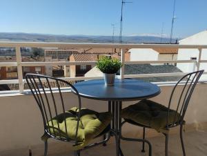 uma mesa azul e duas cadeiras numa varanda em Aurora em Ávila