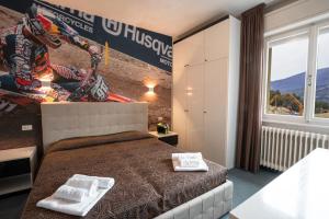 ein Schlafzimmer mit einem Bett mit zwei Handtüchern darauf in der Unterkunft Hotel Ciclamino in Pietramurata
