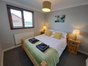 a bedroom with a bed with two towels on it at River Retreat - Norfolk Broads in Brundall