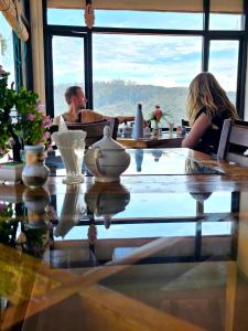 Un uomo e una donna seduti a un tavolo in un ristorante di Chez Allen a Nuwara Eliya