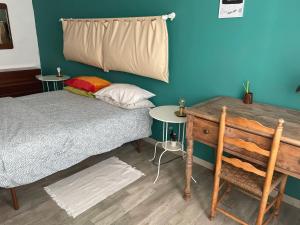 a bedroom with a bed and a wooden desk at Appartamento luminoso in Ciriè