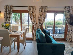 a living room with a blue couch and a table at River Retreat - Norfolk Broads in Brundall
