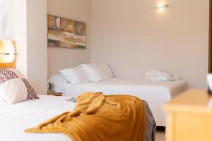 a hotel room with two beds with a blanket on them at La Sort Boutique Hotel in Moraira