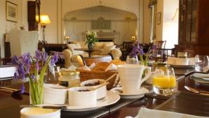 stół z kubkami i talerzami żywności w obiekcie Edgcott House w mieście Exford