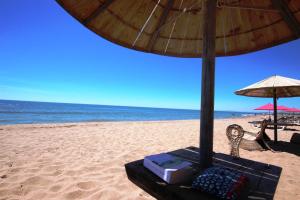 - une table avec un parasol sur la plage dans l'établissement Maison de vacances, MAS DE LA PLAGE, clim, terrasse Sud dégagée 4 couchages, 200m de la mer, PORTIRAGNES PLAGE LRMP67, à Portiragnes