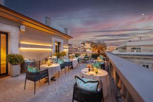 a restaurant with tables and chairs on a balcony at Singer Palace Hotel Roma in Rome