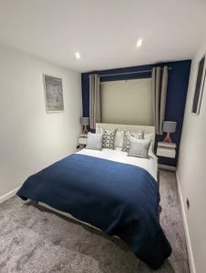 une chambre avec un grand lit et une tête de lit bleue dans l'établissement 1 Bed Apartment Near Vibrant Bethnal Green, à Londres