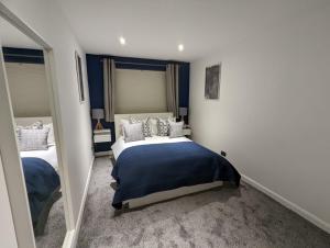 a bedroom with a blue and white bed and a mirror at 1 Bed Apartment Near Vibrant Bethnal Green in London