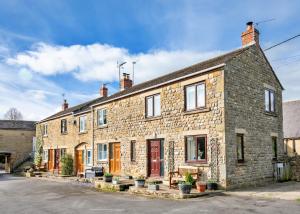 a stone house with a red door on a street at Finest Retreats - Tyg Cottage in Ripon