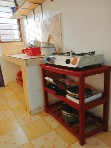 cocina con fogones y mesa con ollas y sartenes en Tranquil Terrace Cottages Diani, en Diani Beach