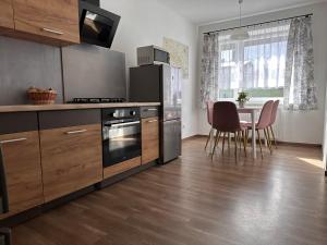 Una cocina con gabinetes de madera y una mesa con sillas. en Agroturystyka Pod Świerkami, en Marciszów