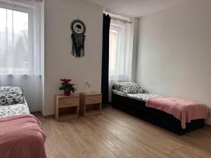 Un dormitorio con dos camas y un espejo en la pared. en Agroturystyka Pod Świerkami, en Marciszów
