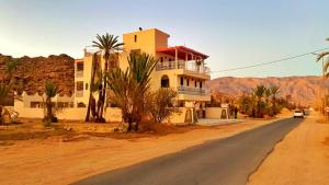 a house on the side of a road in the desert at Dar izem in Tafraout
