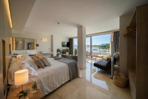 a bedroom with a large bed with a view of the ocean at La Sort Boutique Hotel in Moraira +37 photos