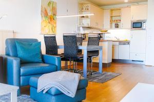 een woonkamer met een blauwe stoel en een tafel bij Strandpalais PE08 in Cuxhaven