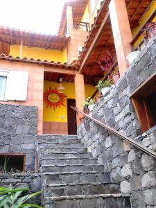 una casa con una pared de piedra y escaleras delante en Pousada do Ceu, en Paul