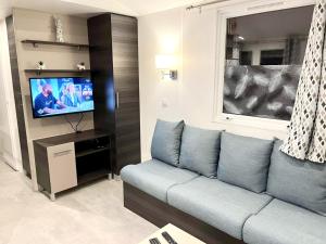a living room with a couch and a tv at Bungalow charmant au cœur de Les Mathes avec piscine partagée in Les Mathes