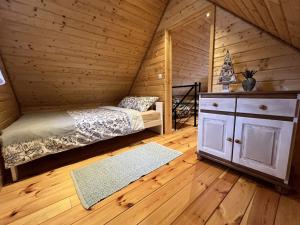 a bedroom with a bed in a log cabin at Domek w Górach Bardzkich in Kamieniec Ząbkowicki