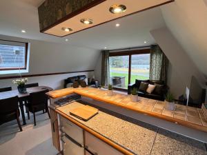 Caledonia Lodge في سبين بريدج: مطبخ وغرفة معيشة مع أريكة وطاولة