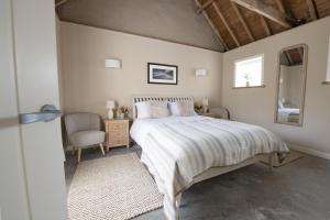 una camera con letto, sedia e specchio di Flittermouse Barn a Goxhill