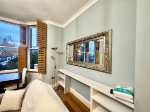 a bedroom with a mirror on the wall and a desk at Spacious 2 bedroom apartment in London