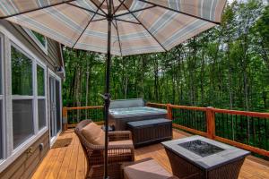 a deck with an umbrella and a table and chairs at Lessons from Mars in Banner Elk