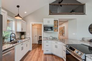 a kitchen with white cabinets and marble counter tops at Lessons from Mars in Banner Elk