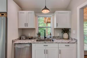 a kitchen with white cabinets and a sink and a window at Lessons from Mars in Banner Elk