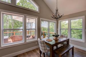 a dining room with a table and chairs and windows at Lessons from Mars in Banner Elk