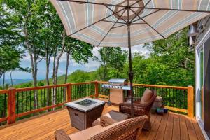 a patio with an umbrella and chairs on a deck at Lessons from Mars in Banner Elk