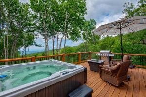 a hot tub on a deck with an umbrella at Lessons from Mars in Banner Elk