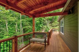 a wooden porch with a bench on a deck at Lessons from Mars in Banner Elk