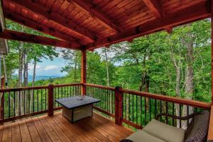 a porch with a table and chairs on a deck at Lessons from Mars in Banner Elk