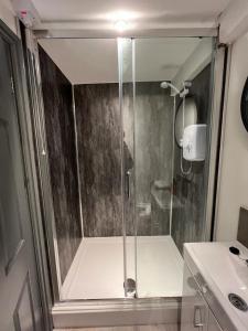 a shower with a glass door next to a sink at Guest Homes - Eign Street Apartments in Hereford