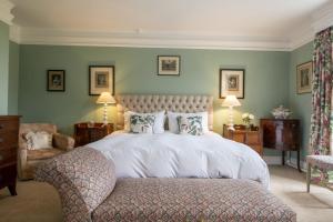 a bedroom with a large white bed and a chair at Upper Helmsley Hall 20 in Upper Helmsley