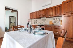 uma cozinha com uma mesa com uma toalha de mesa branca em Ghivine Albergo Diffuso em Dorgali