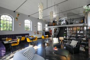 une grande chambre avec des chaises, des tables et un escalier dans l'établissement Valerius Boutique Hotel, à Wormer