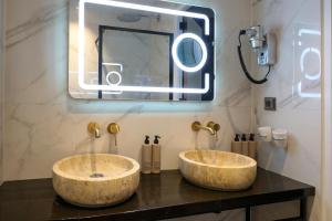 two sinks on a counter in a bathroom with a mirror at Valerius Boutique Hotel in Wormer