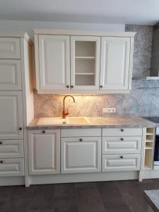 a kitchen with white cabinets and a sink at Apartment Huter in Jerzens
