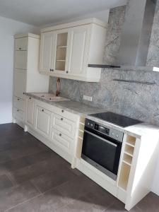 a kitchen with white cabinets and a stove top oven at Apartment Huter in Jerzens