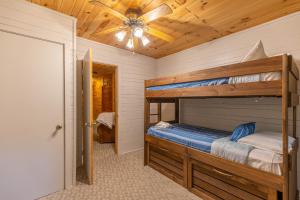 1 Schlafzimmer mit 2 Etagenbetten und einem Deckenventilator in der Unterkunft A Dog's Dream in Boone