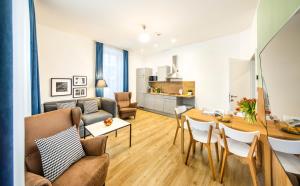 a living room and kitchen with a table and a couch at Jimmy's Apartments Emerald in Vienna